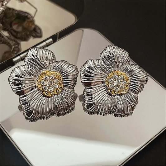 Woman in professional attire wearing simple gold stud earrings, office setting