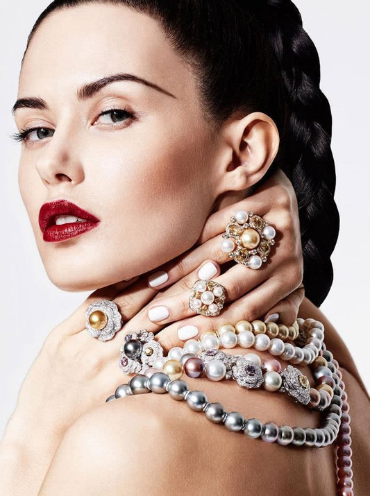 Professional woman at her desk wearing simple gold stud earrings and a thin necklace