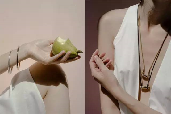 Close-up of a woman's collarbone wearing a delicate gold pendant necklace, soft natural light