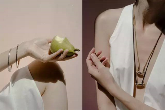 Close-up of a woman's collarbone wearing a delicate gold pendant necklace, soft natural light